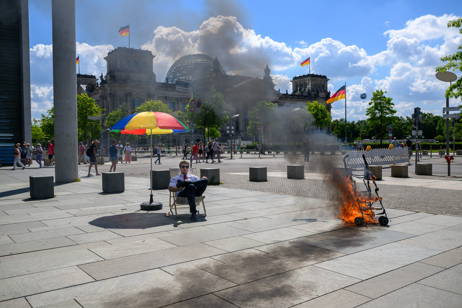 Fotoaktion des Aufstands der Letzten Generation vor dem Reichstag in Berlin am 02.07.2022: vor dem Gebäude des Bundestags brennt das Gestell eines Kinderwagens